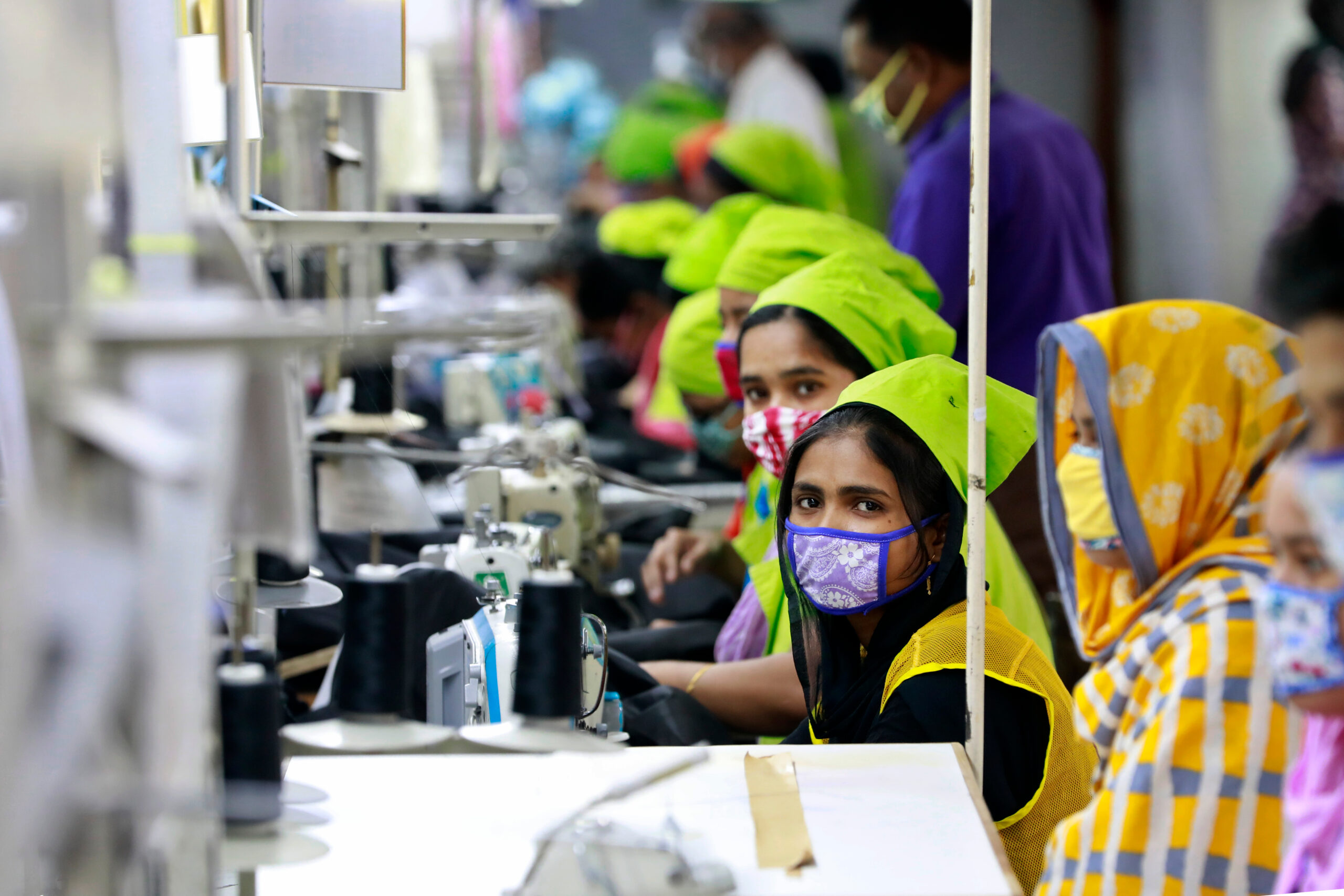 Workers producing personal protective equipment for health professionals at a garment factory in Dhaka