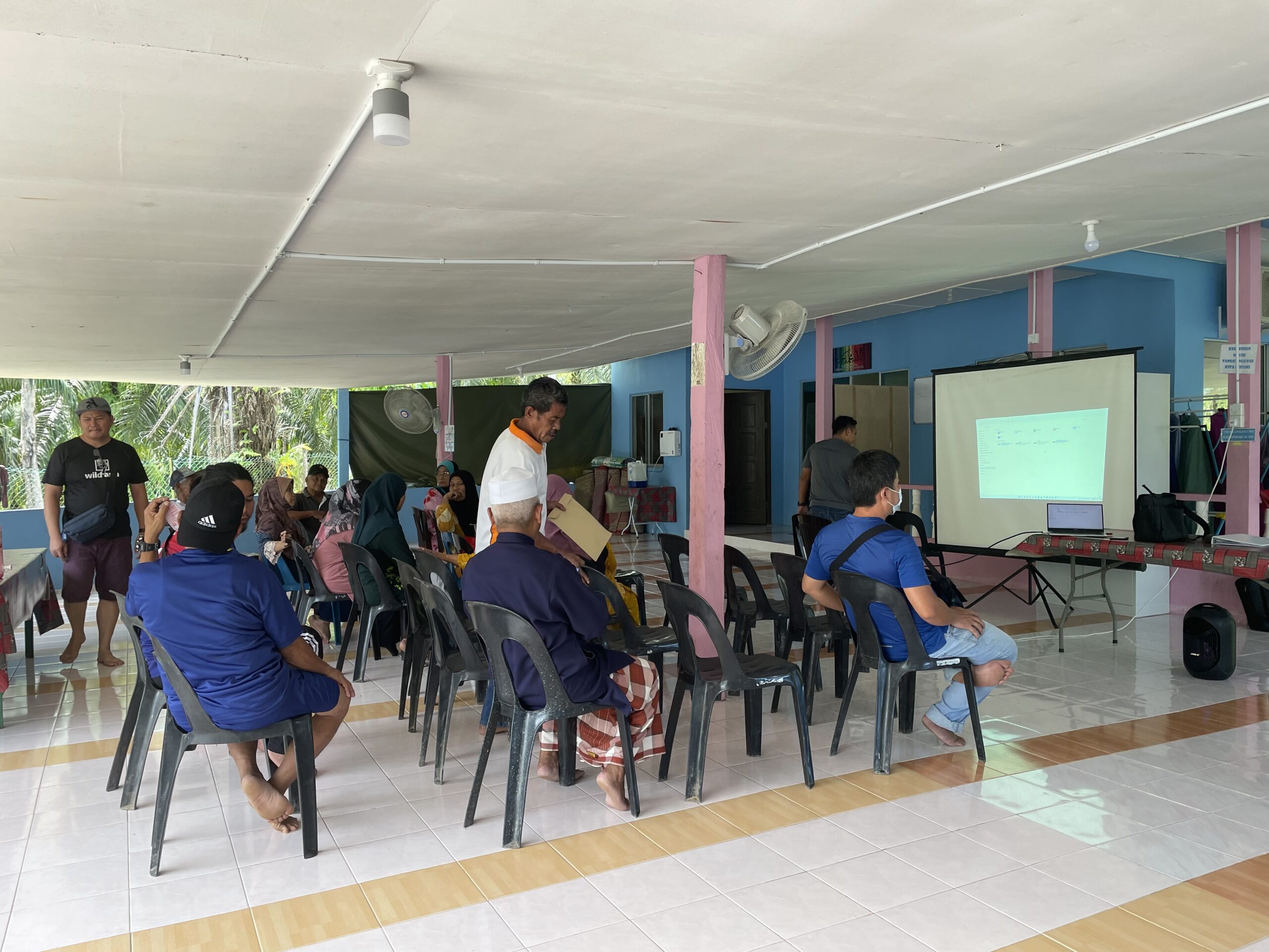 Palm oil farmers looking at device